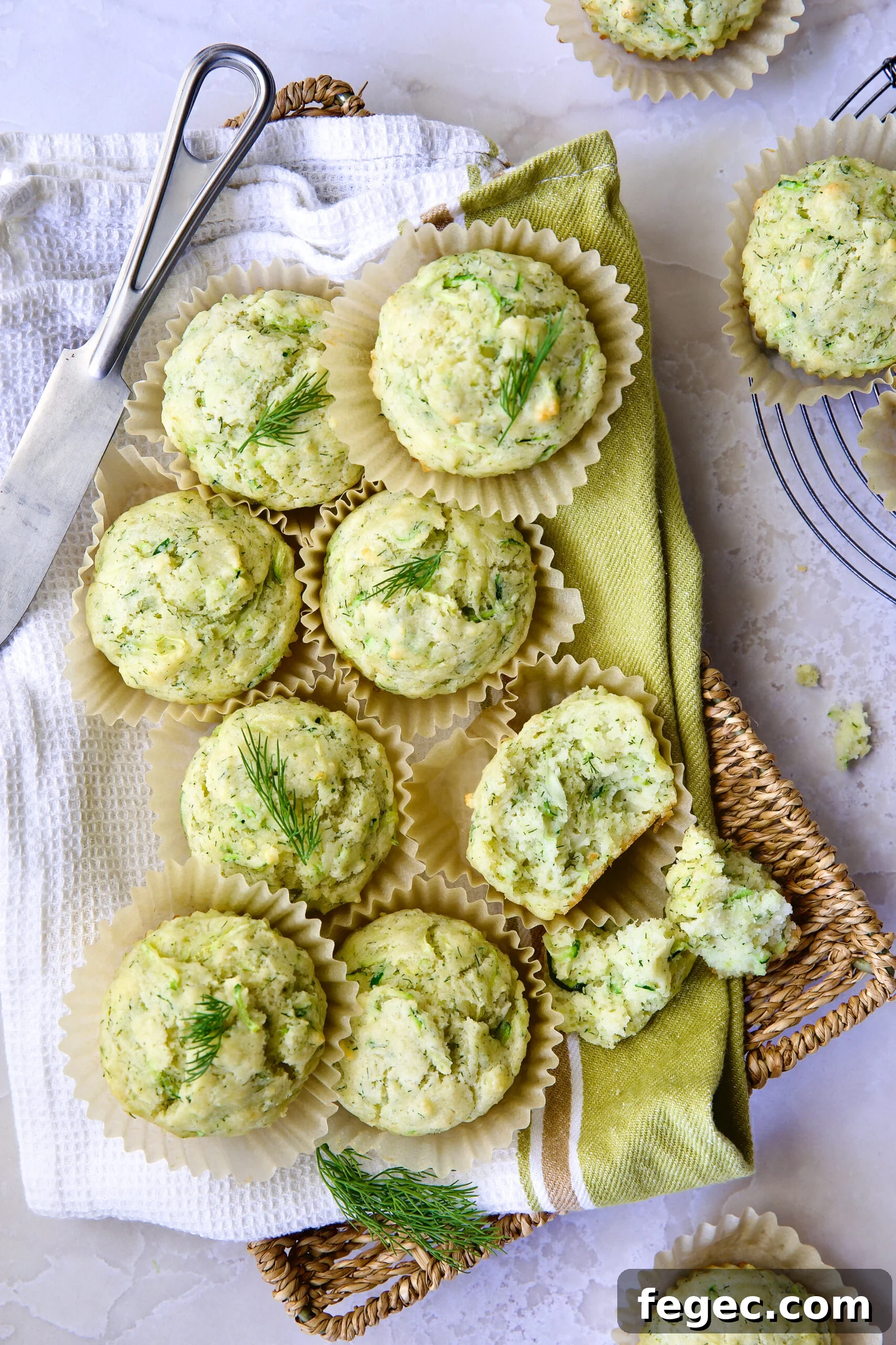 Pile of Dill Zucchini and Ricotta Muffins on square rattan basket.