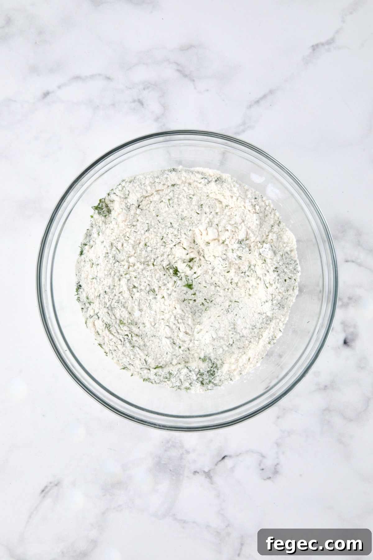 Dry ingredients for muffins in a glass bowl.