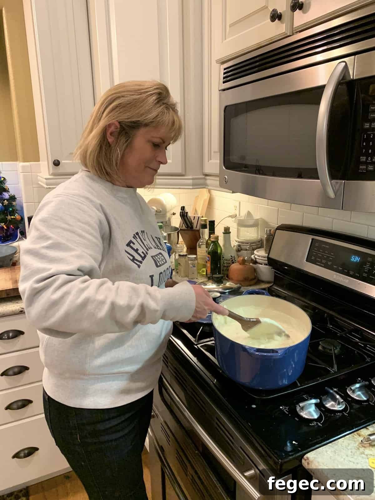 Melinda stirring clam chowder at the stove.