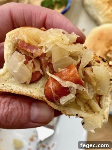 A hand holding grown-up pigs in blanket.
