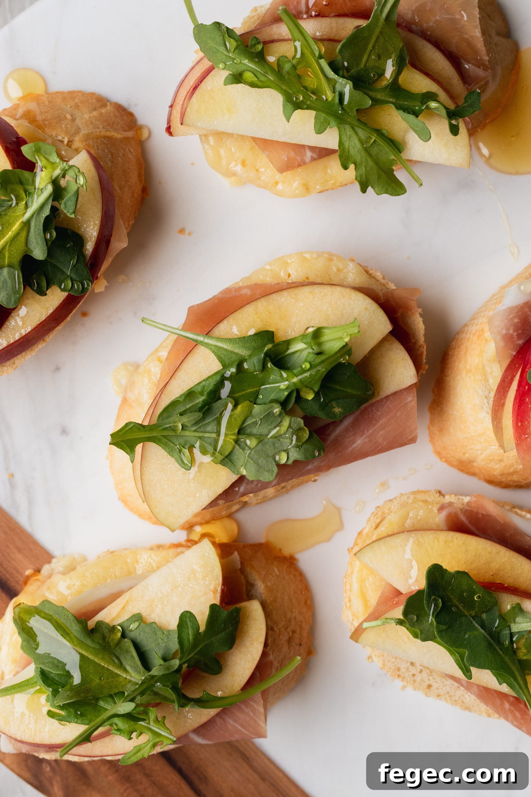 White Cheddar + apple crostini with arugula, prosciutto, and honey