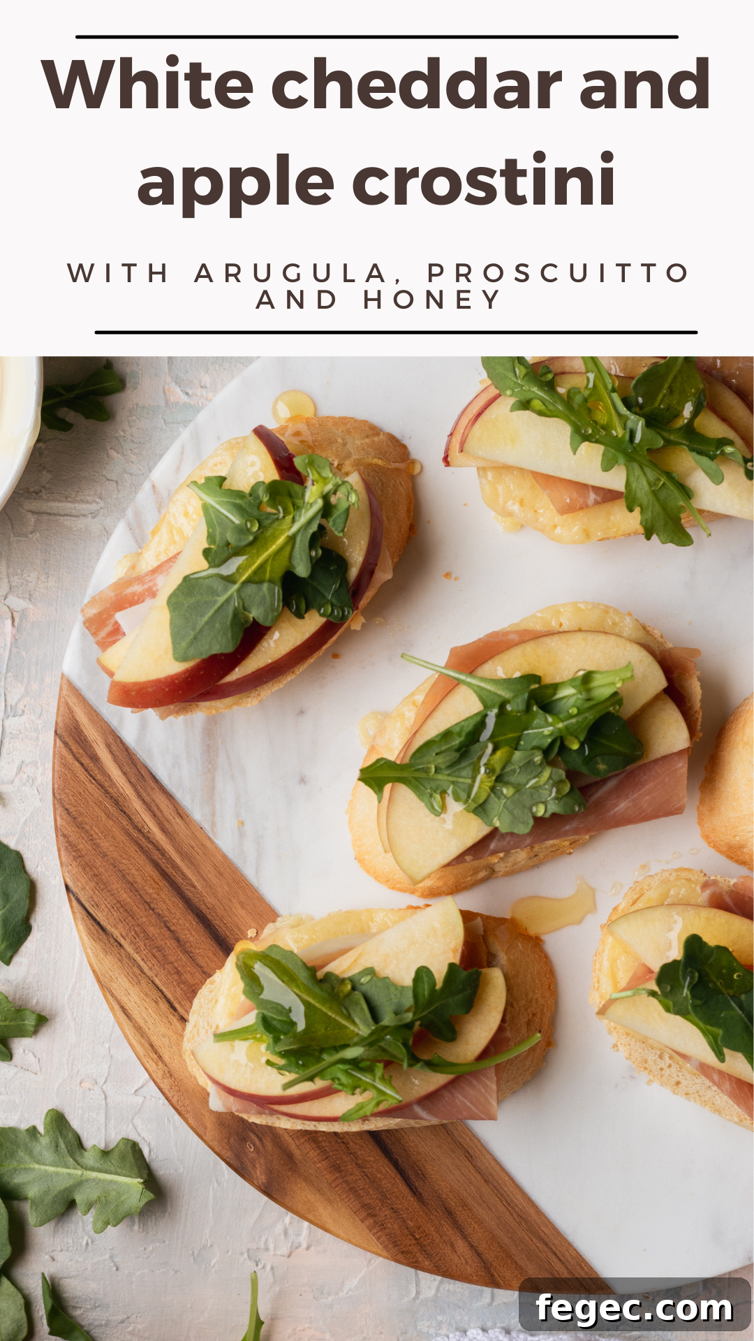 The perfect holiday appetizer: this white cheddar and apple crostini! Topped with prosciutto, arugula, and with a drizzle of honey, it's a 6 ingredient appetizer that requires just minutes of hands-on time and is a true crowd-pleaser!