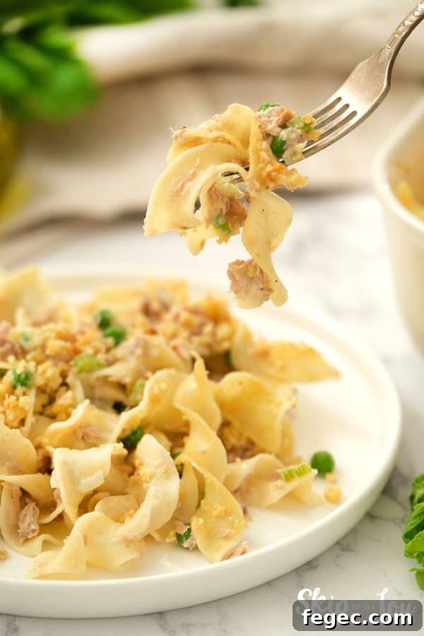 Tuna Noodle Casserole served on a white dish with a bite on a fork.