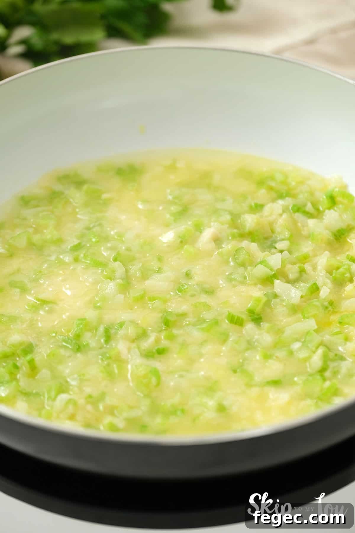 Onion and celery cooking in a large pan in butter.