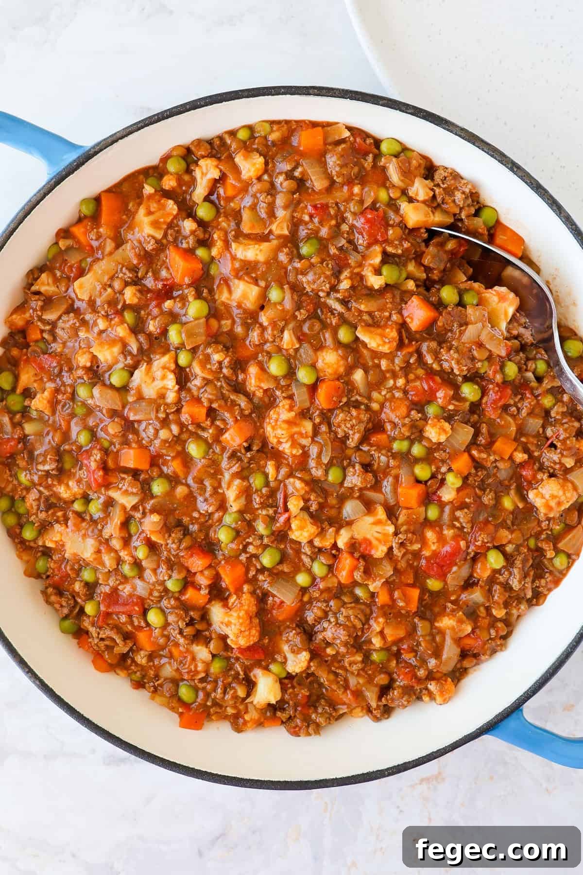 Savoury mince in a skillet scooped with a spoon.