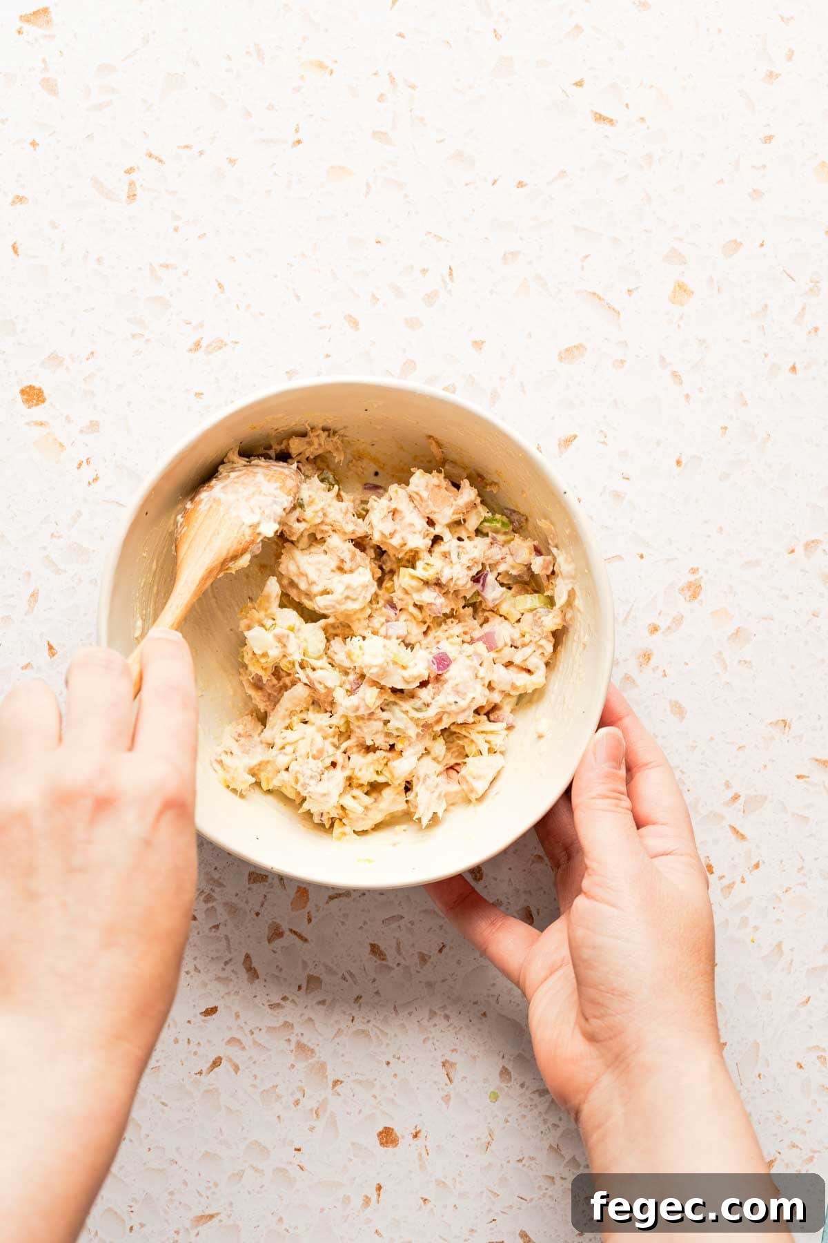 Crispy Tuna Melt Wrap Recipe for Quick Lunch or Picnic 5 spoon mixing tuna salad in bowl.