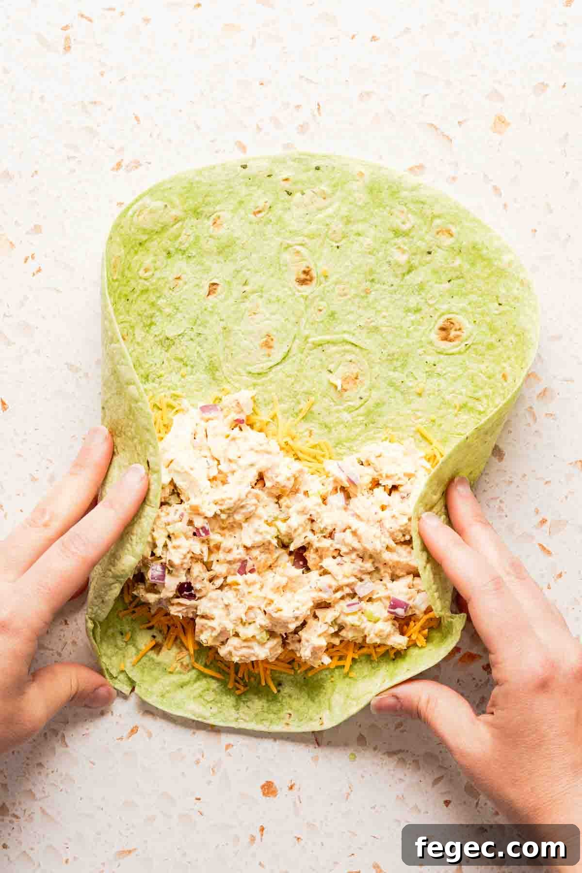 Crispy Tuna Melt Wrap Recipe for Quick Lunch or Picnic 9 sides of tortilla being folded in with hands.