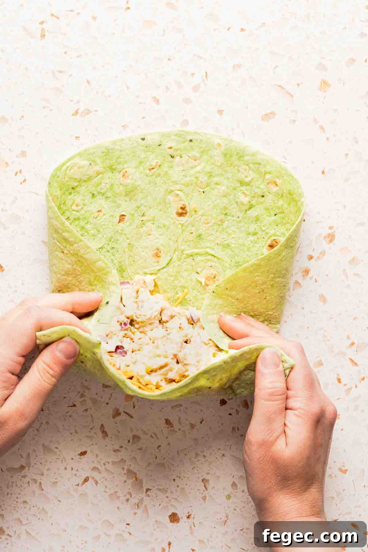 Crispy Tuna Melt Wrap Recipe for Quick Lunch or Picnic 10 tuna melt wrap being rolled with sides tucked in.