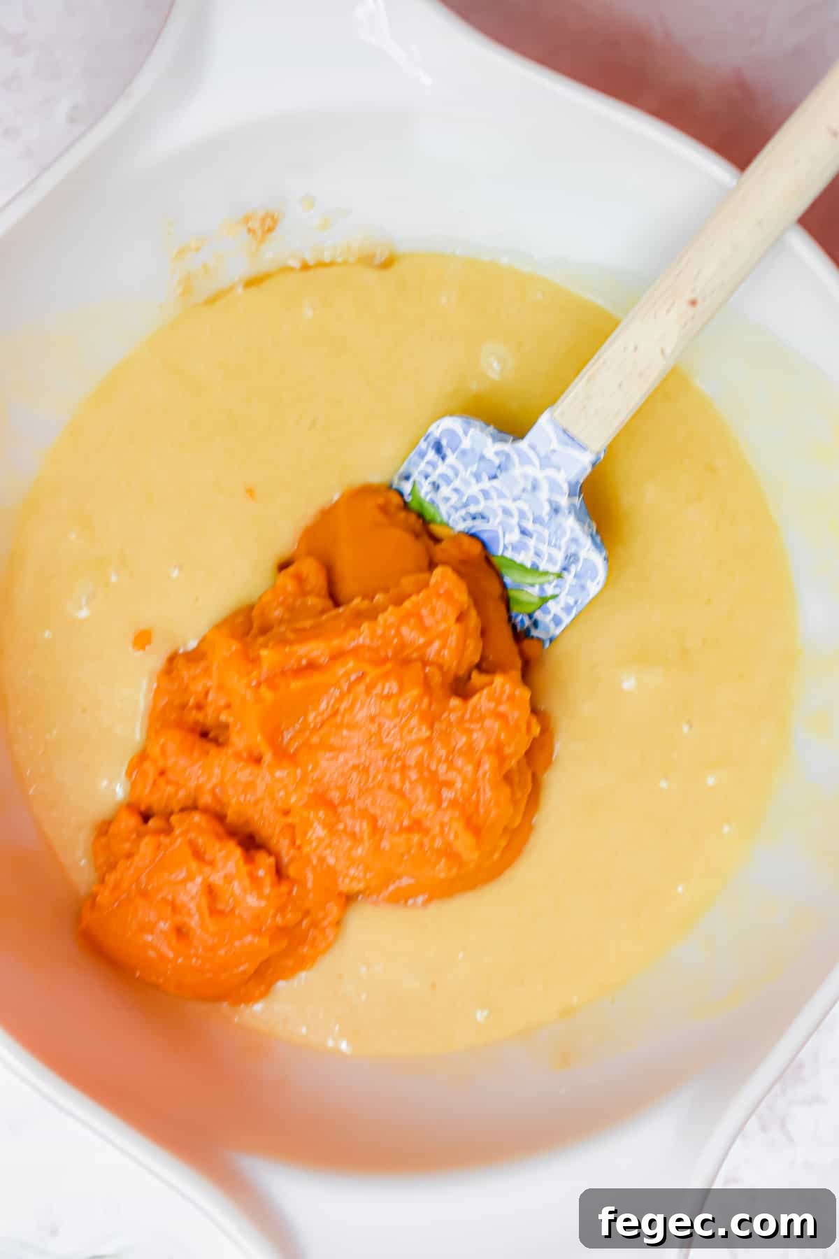 The pumpkin puree is added to the bowl.