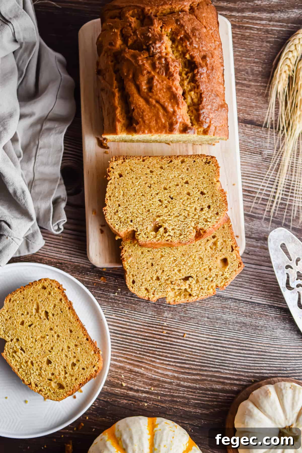 An overhead shot of the pumpkin bread surrounded by pumpkins and slices of bread.