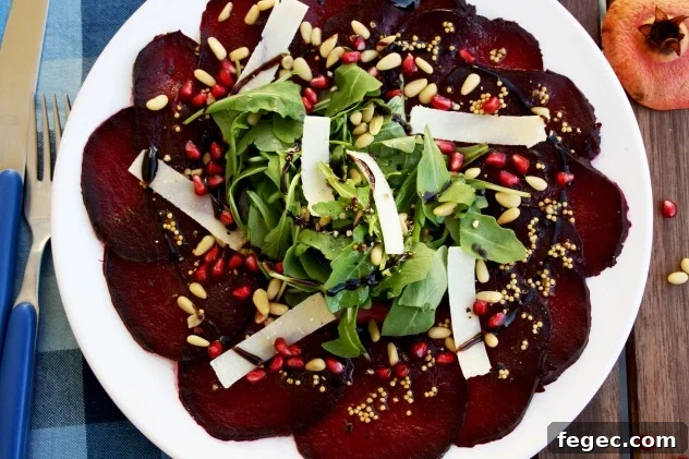 A beautiful, effortless, healthy and flavorful beetroot carpaccio with orange mustard vinaigrette and pomegranate seeds, served with parmesan and arugula.4