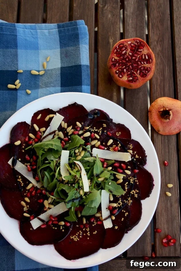 A beautiful, effortless, healthy and flavorful beetroot carpaccio with orange mustard vinaigrette and pomegranate seeds, served with parmesan and arugula.