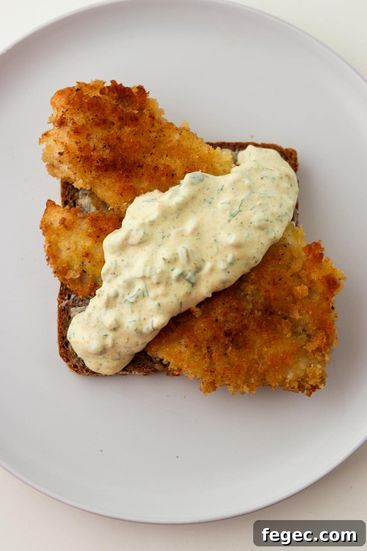Pan-fried fish on rye bread covered with Danish remoulade sauce.