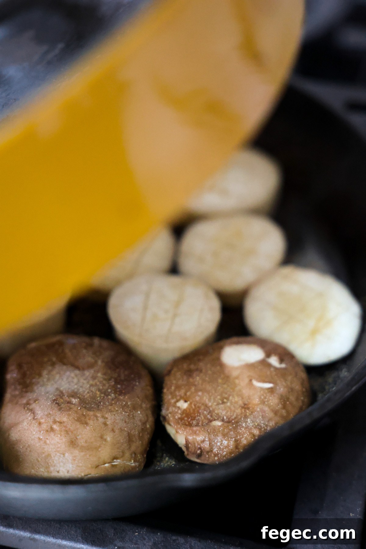 Placing a mushroom press on cooking mushrooms.