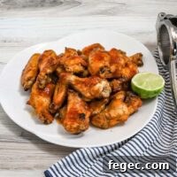 Hot honey chicken wings preparation with hot sauce, butter, honey, lime zest and juice, garlic powder, and onion powder.