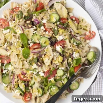 Gluten-free pasta salad with tomatoes, cucumber, pine nuts, herbs, and more.