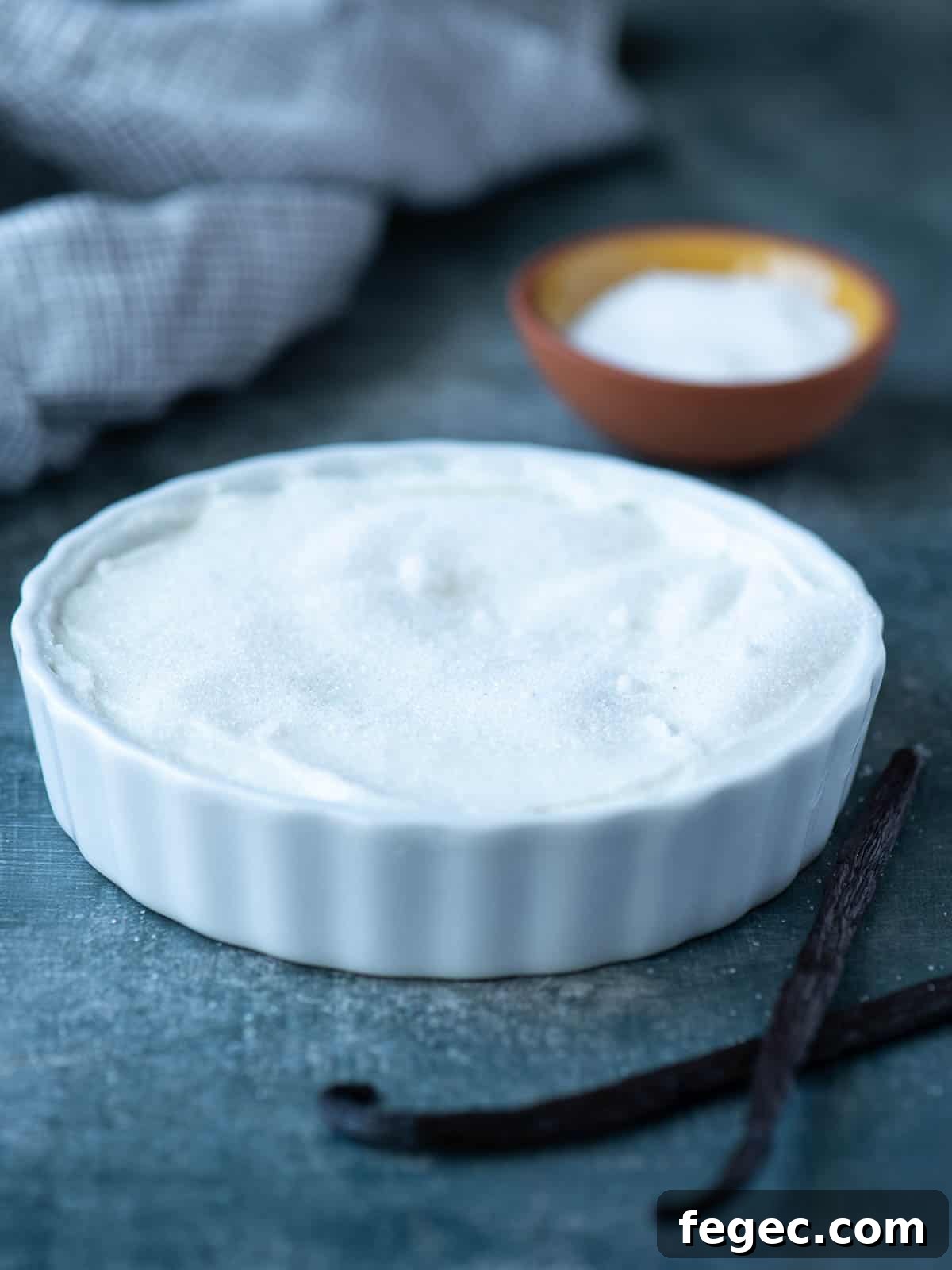 Sugar over on top of yogurt in a white ramekin.