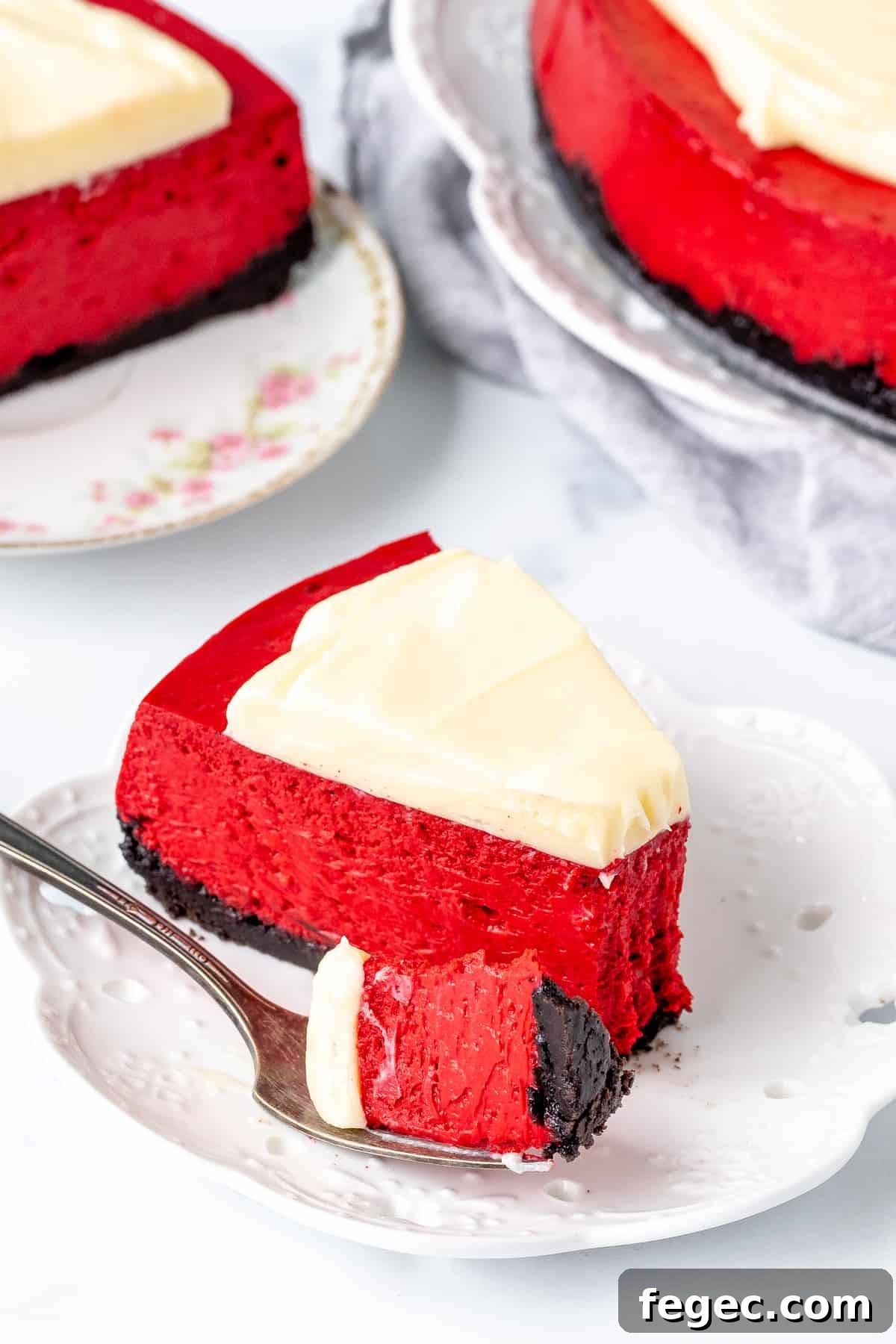 Slice of red velvet cheesecake with a bite taken out of it