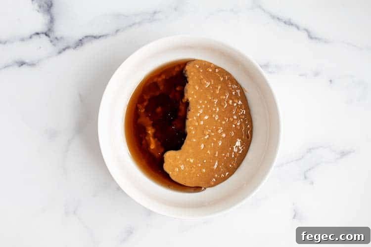 white bowl with peanut butter and maple syrup