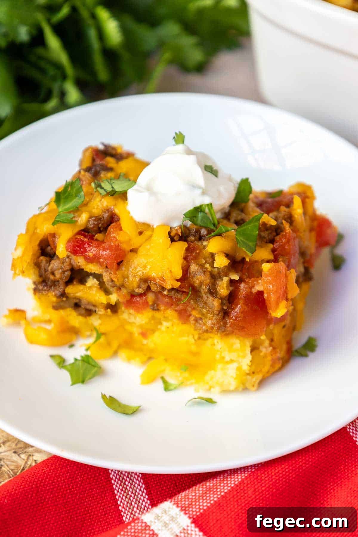 Mexican cornbread casserole topped with sour cream and cilantro.