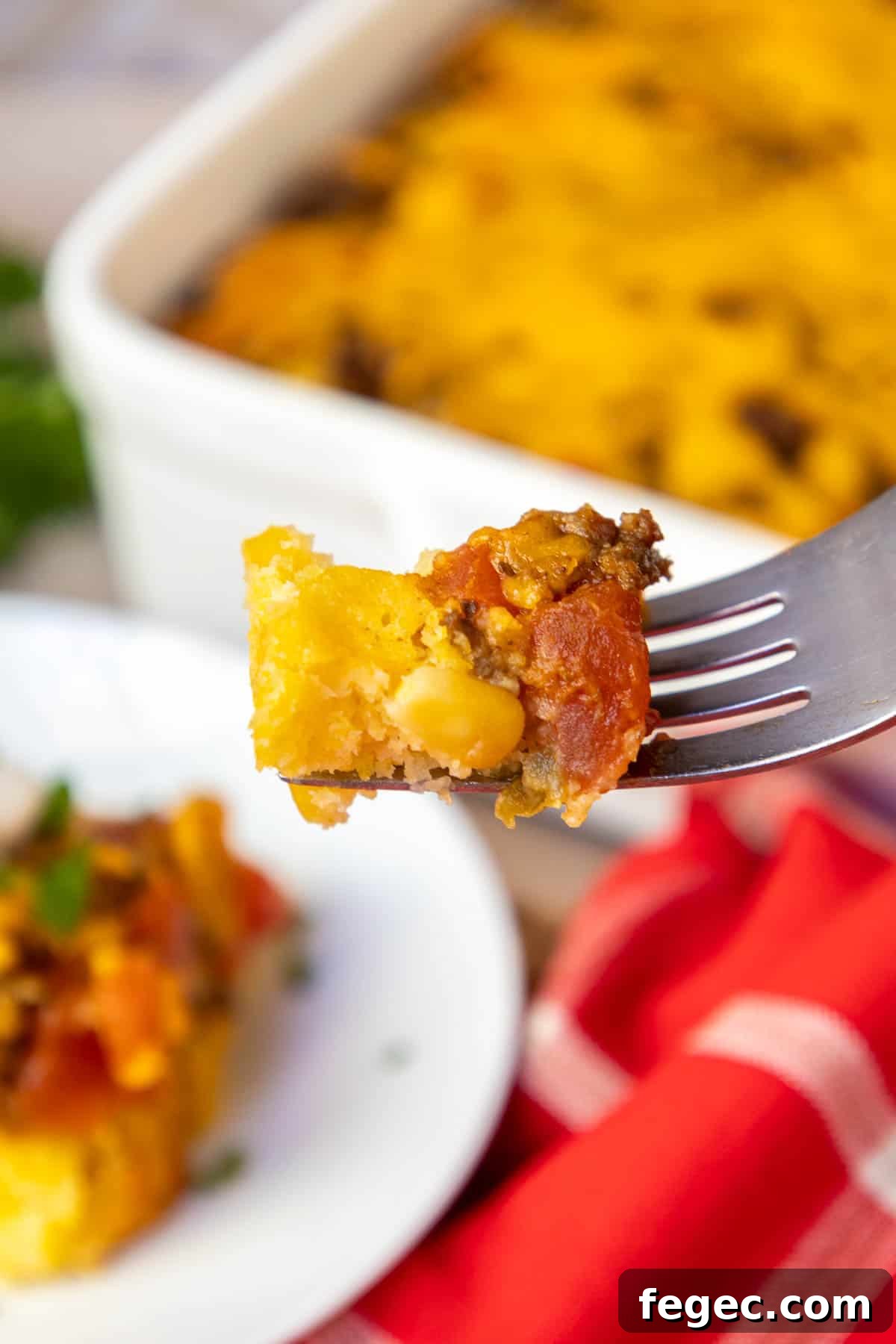 A forkful of the casserole showing the cornbread layer and the beef layer.