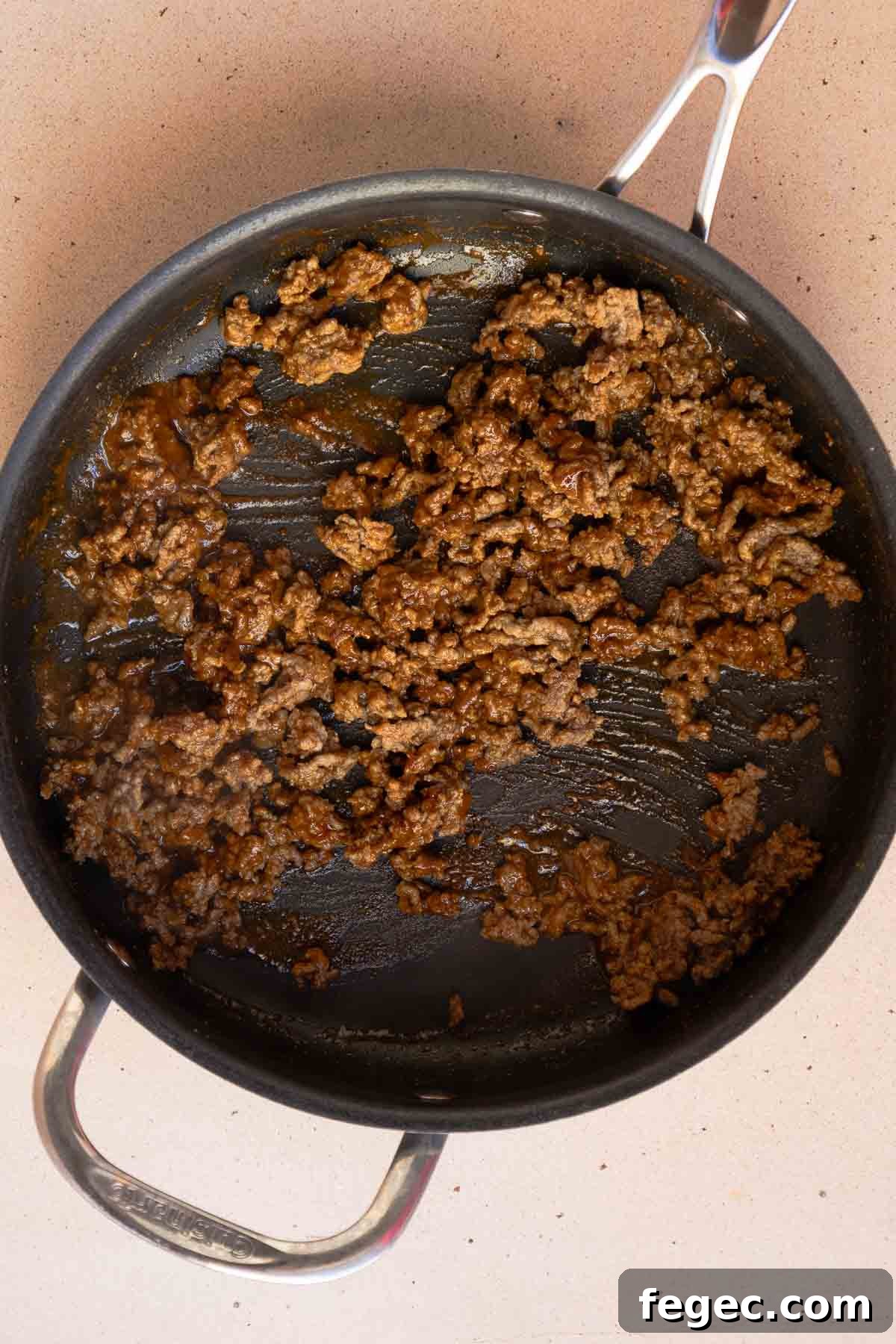 The ground beef is simmered in the taco seasoning and water until thickened.