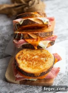 3 sandwiches lined up on a chopping board with focus on middle sandwich