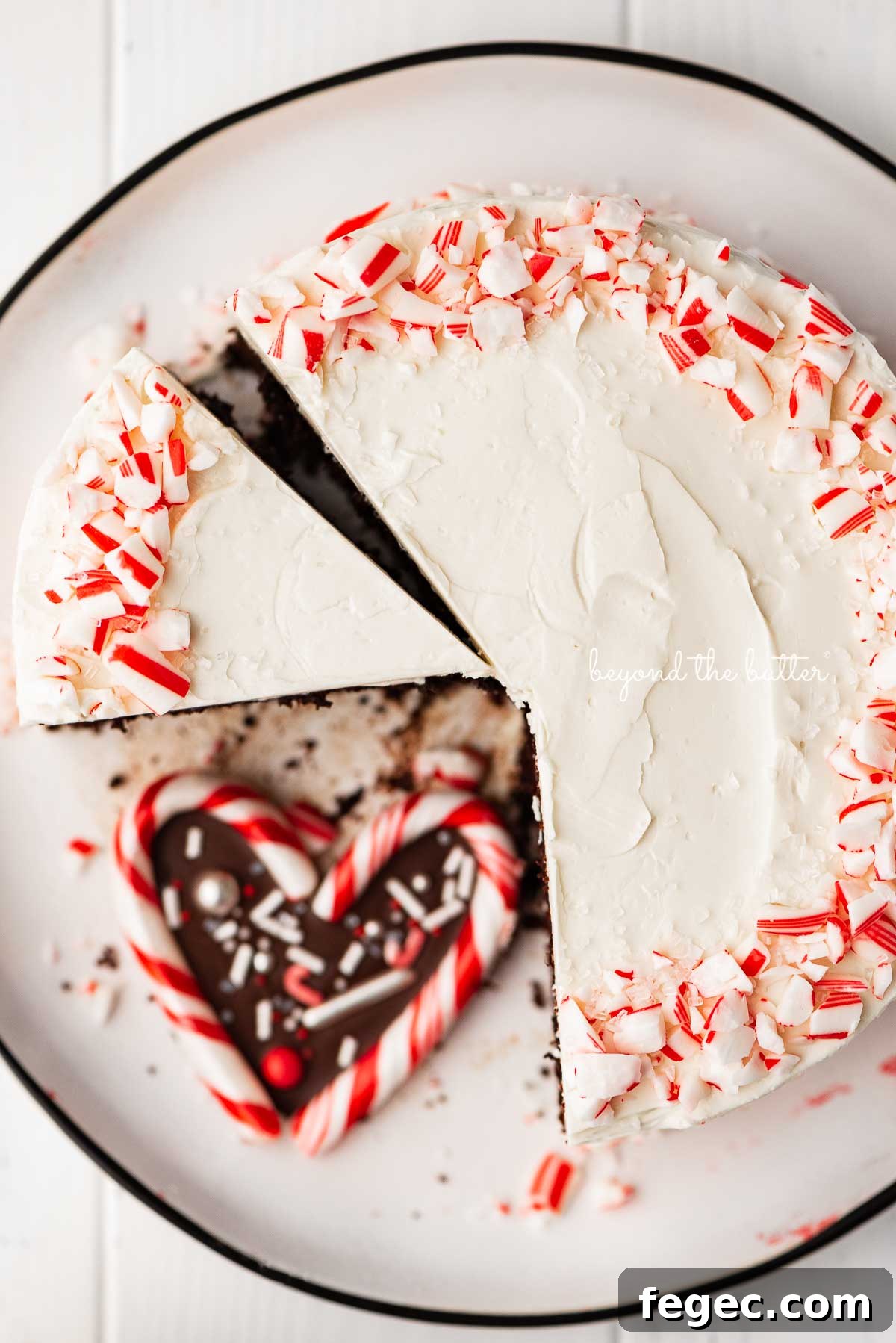 Single layer chocolate peppermint cake sliced with candy cane heart placed on the dessert plate | © Beyond the Butter®