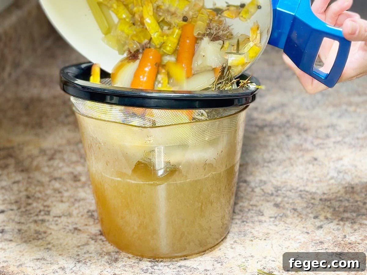 Straining the shrimp stock through a mesh sieve.