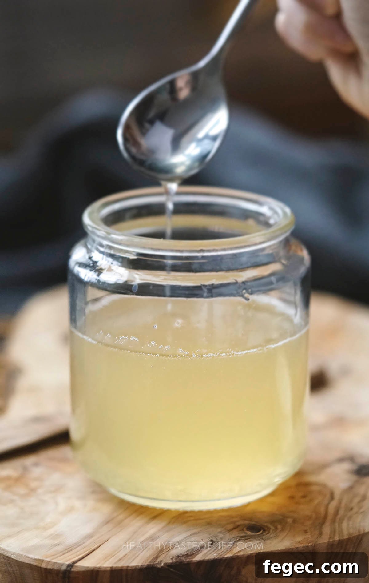 Natural homemade syrup for cough and sore throat in a jar mixed with a spoon.