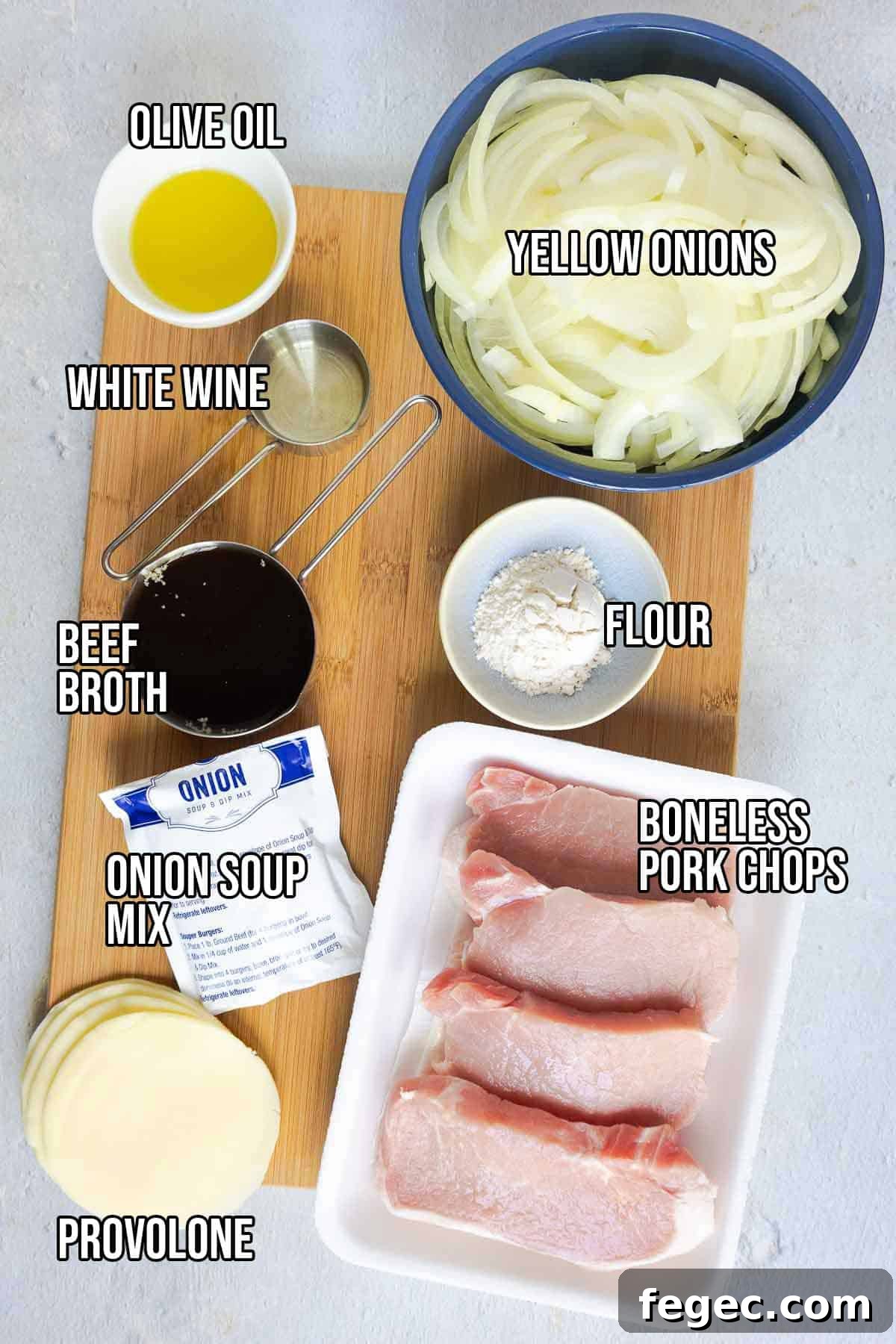 French Onion Pork Chops with Melted Gruyère and Caramelized Onions 4 Ingredients on a board including pork chops, sliced onions, olive oil, white wine, beef broth, flour, provolone, and onion soup mix. Text on the image says 'OLIVE OIL', 'WHITE WINE', 'BEEF BROTH', 'ONION SOUP MIX', 'PROVOLONE', 'FLOUR', 'YELLOW ONIONS', 'BONELESS PORK CHOPS'.