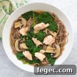 bowl of salmon miso soup with soba noodles, spinach and mushrooms