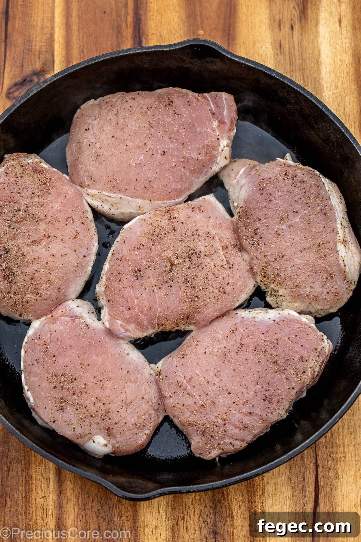Pork chops in a cast iron skillet.