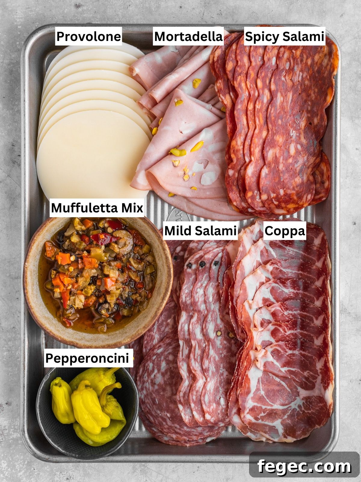 Muffuletta sandwich recipe ingredients with individual labels on a metal tray.