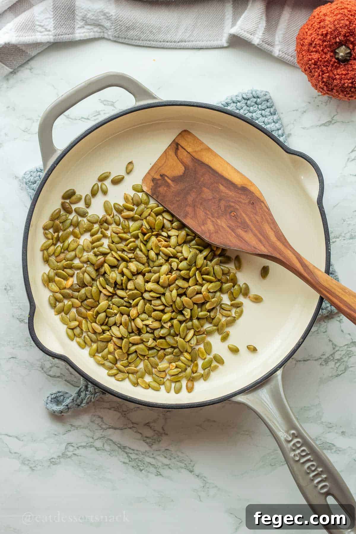 Roasting pepitas in pan with spatula.
