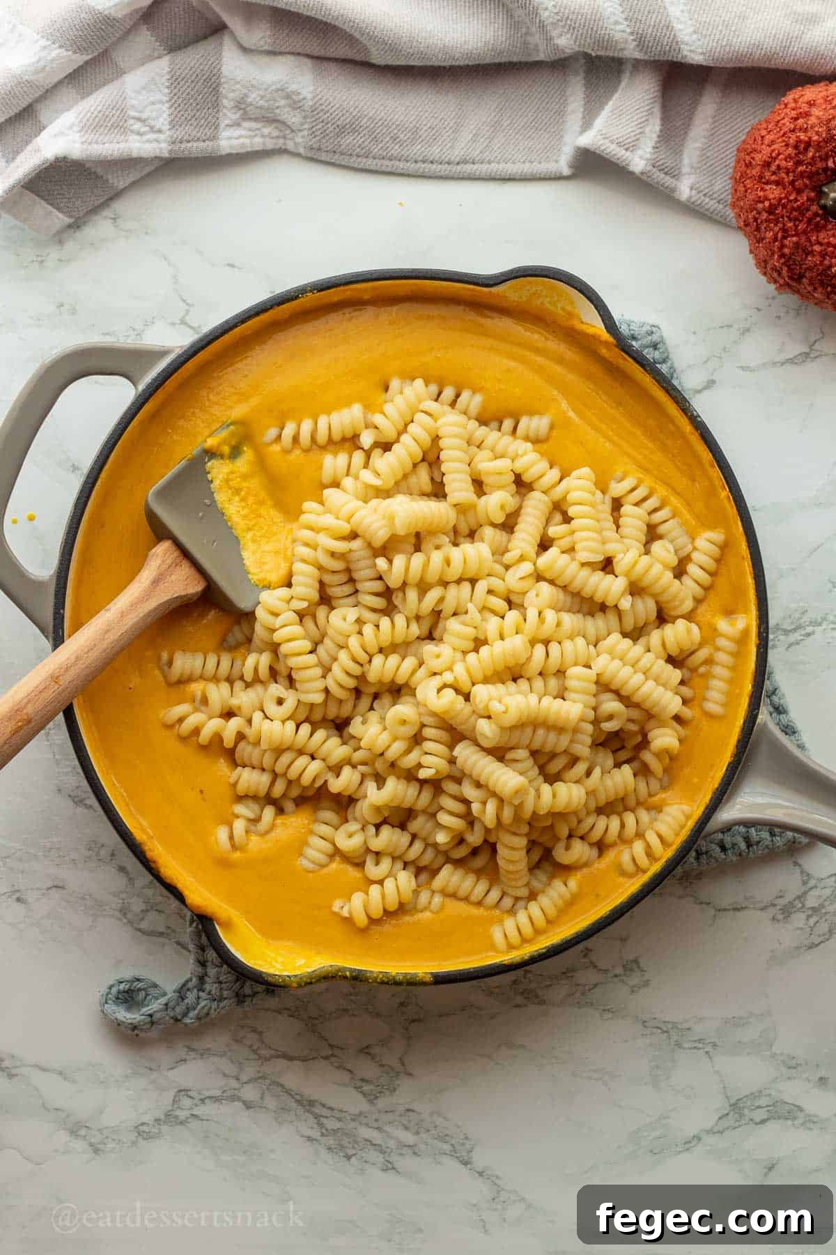 Cooked pasta in pan with pumpkin sauce.