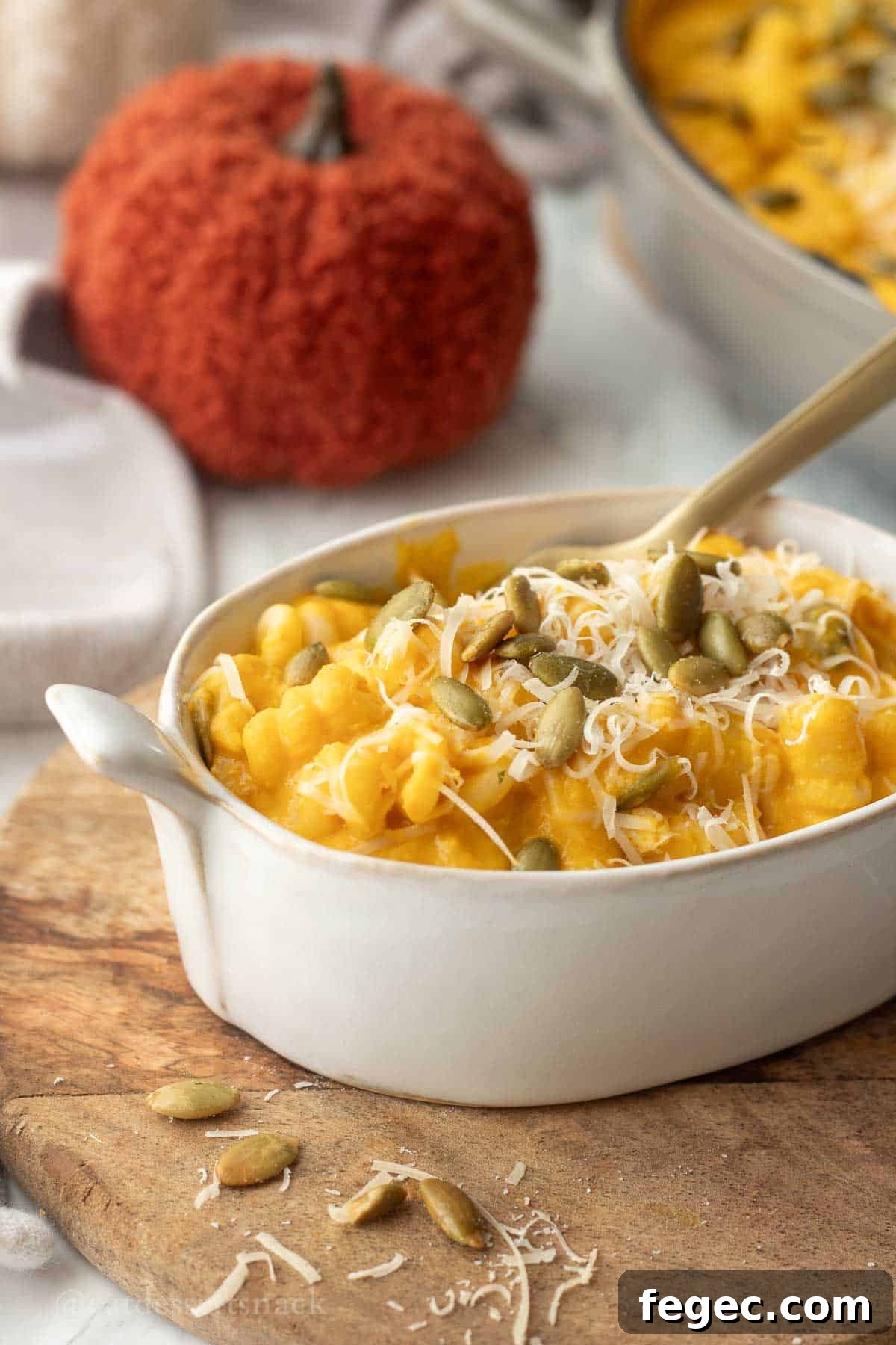 Bowl of pumpkin pasta with gold fork.