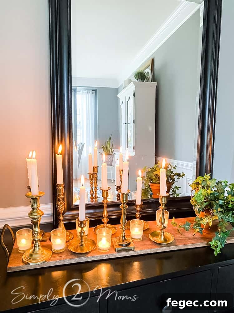 Spring Dining Room Ideas for Greenery Lovers 7 close up of brass candlesticks on wood tray with small glass votives also lit on wood tray on table with mirror behind