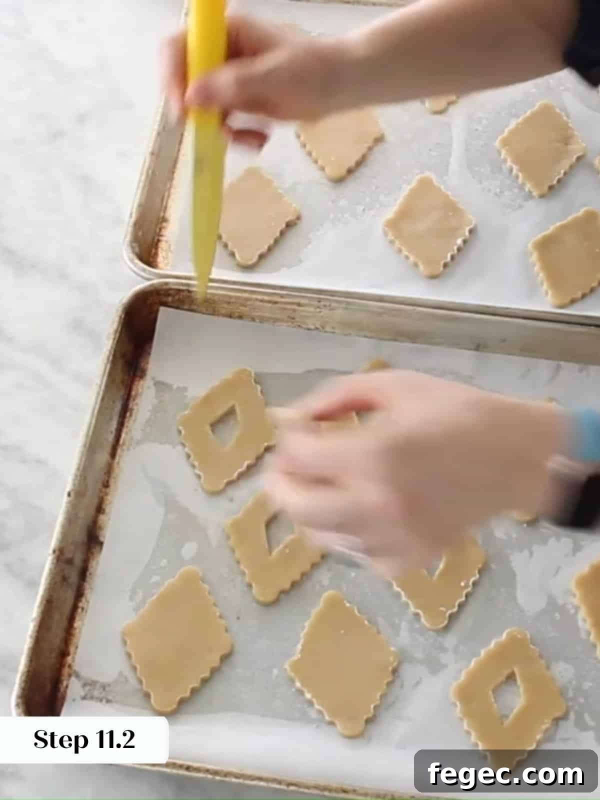 Unbaked Linzer cookies with small center cutouts arranged on parchment paper, ready for baking.