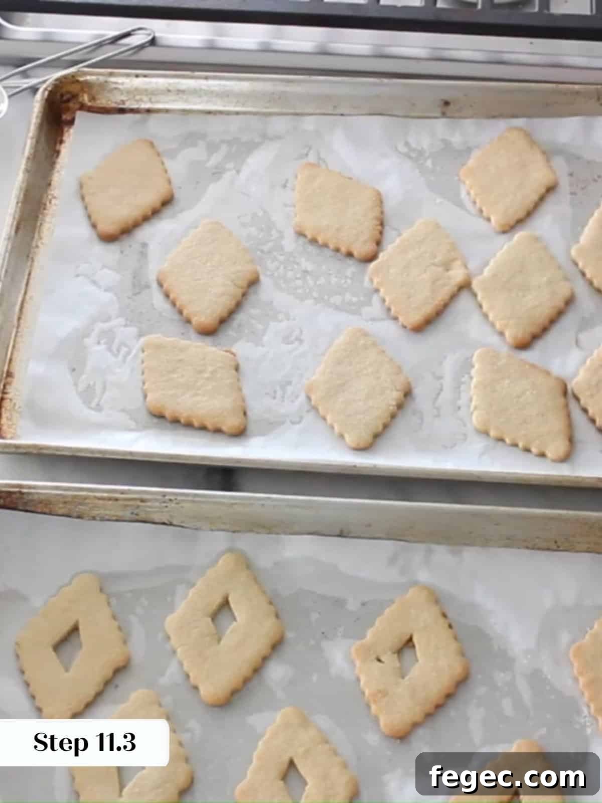 Golden Linzer cookie diamonds cooling on parchment paper after baking.