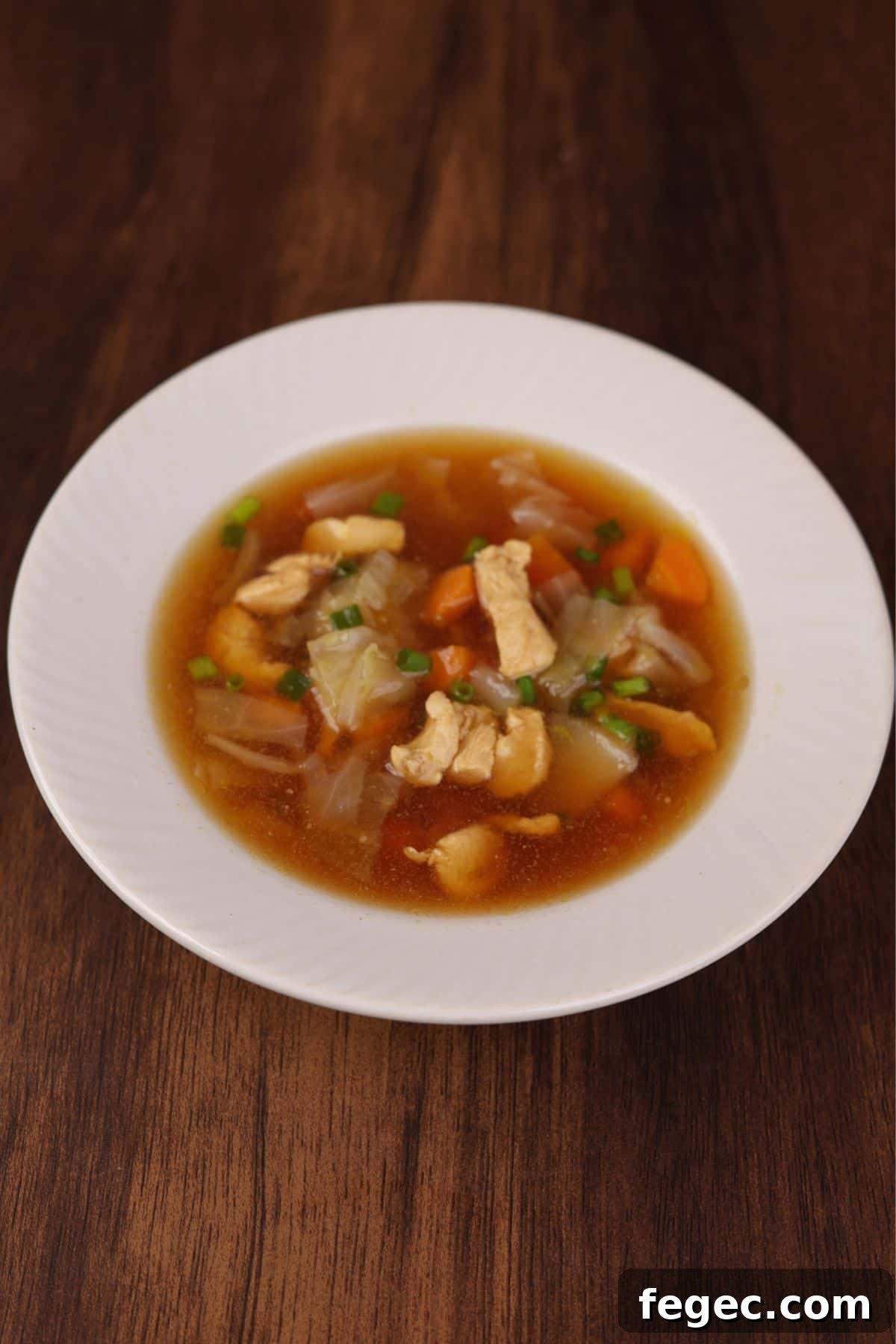 Chicken cabbage soup served in a white bowl.