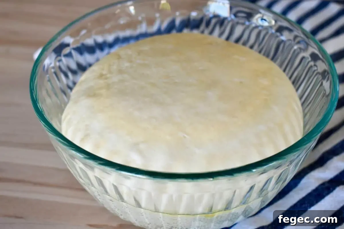 Small batch pizza dough for one pizza in a glass bowl after the dough has risen.