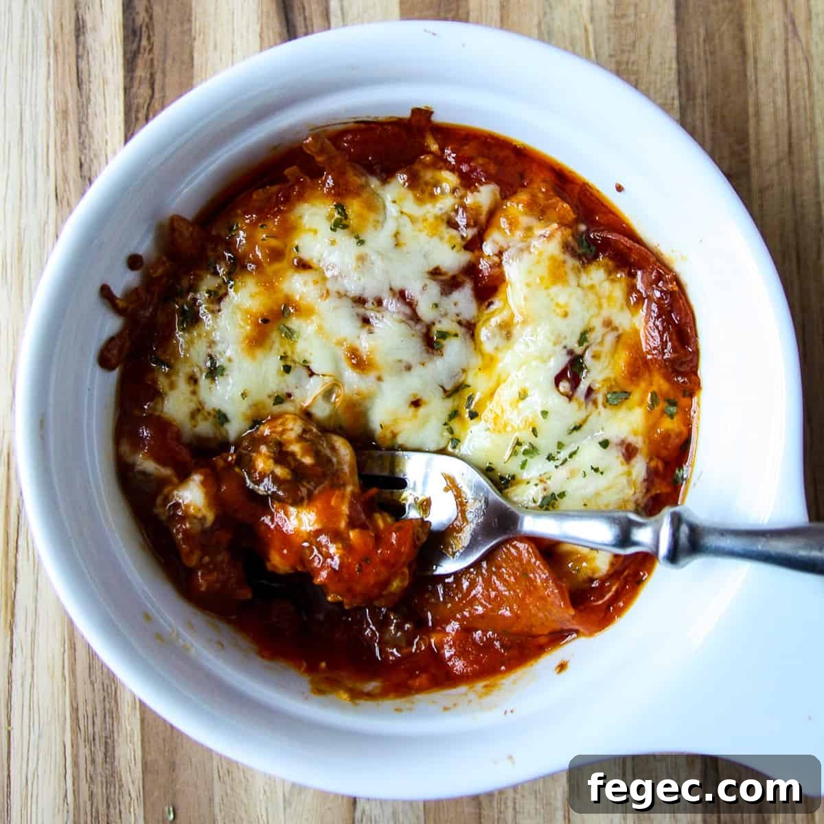 A baked pizza bowl with a fork inserted. 