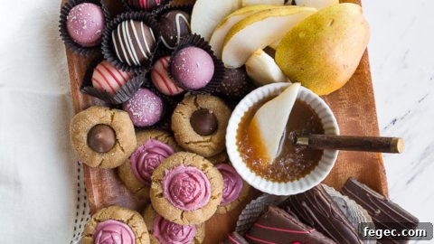 Wooden board with assorted sweets and caramel sauce.
