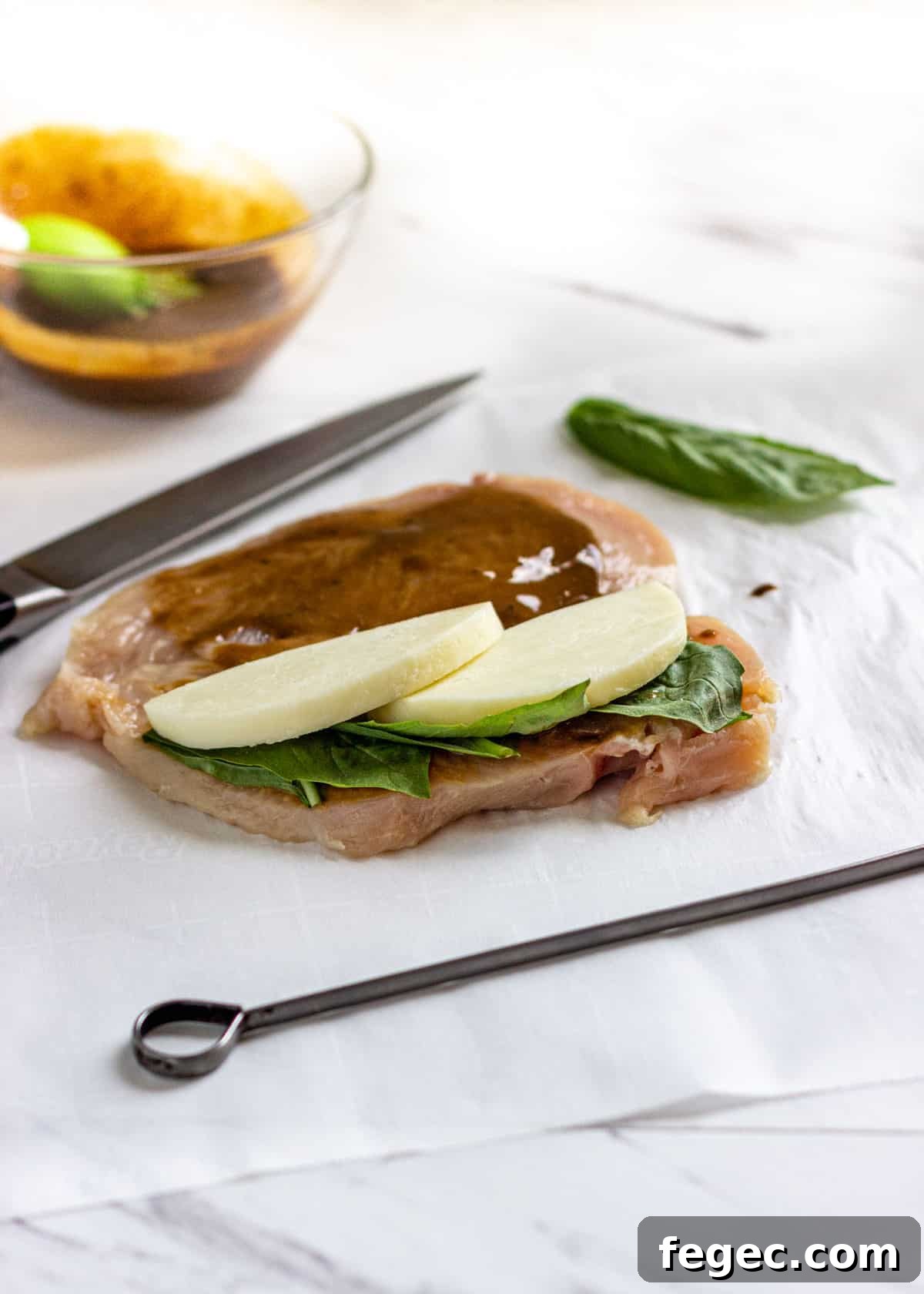raw chicken split in half and filled with mozzarella and basil