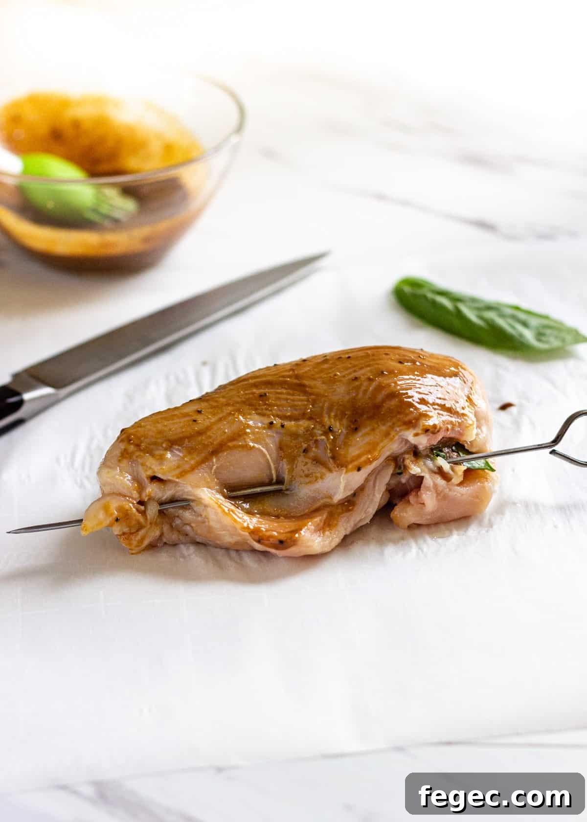 raw chicken filled with sun-dried tomatoes, mozzarella, and basil and closed with a skewer
