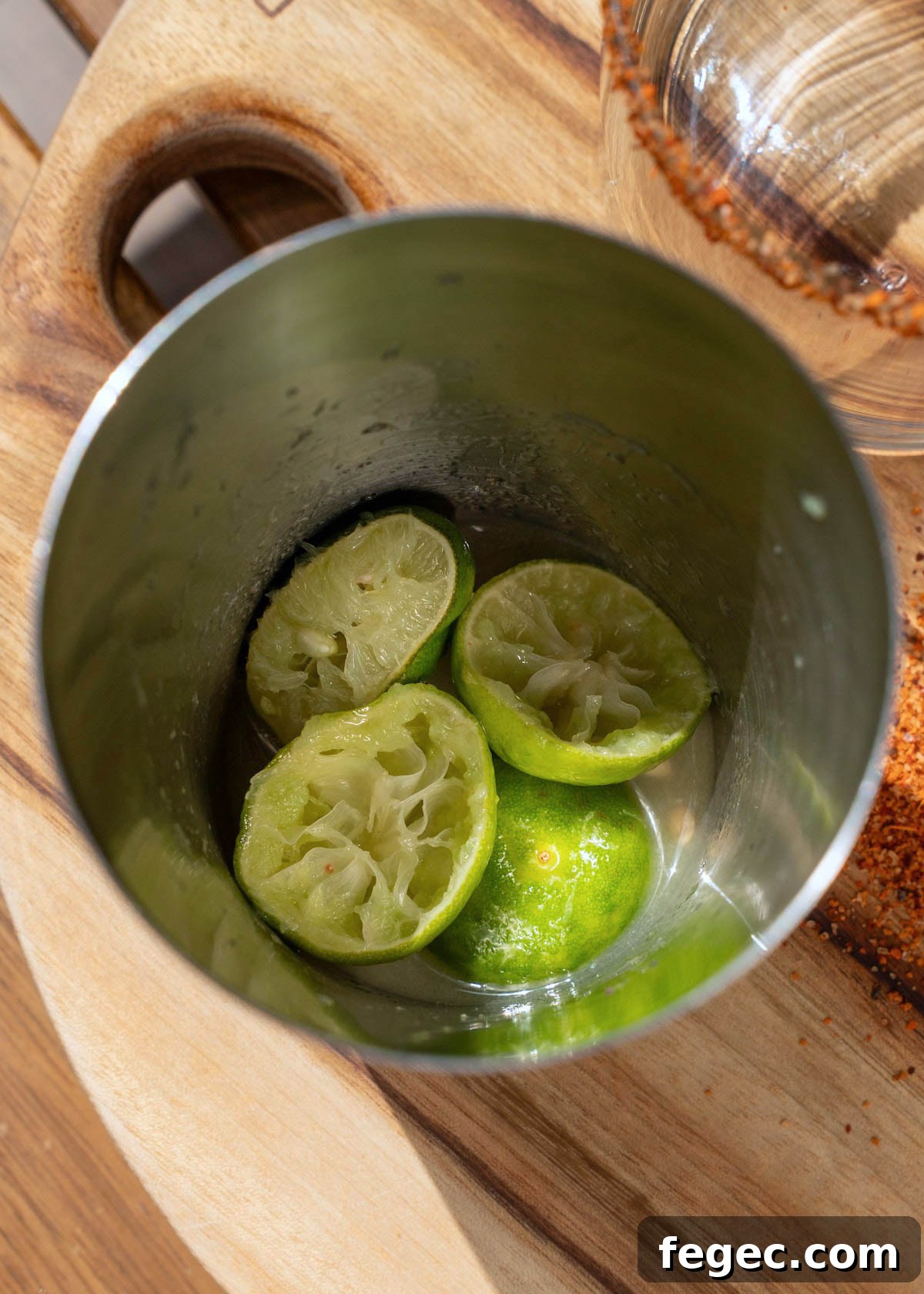 key limes muddled with salt in a shaker