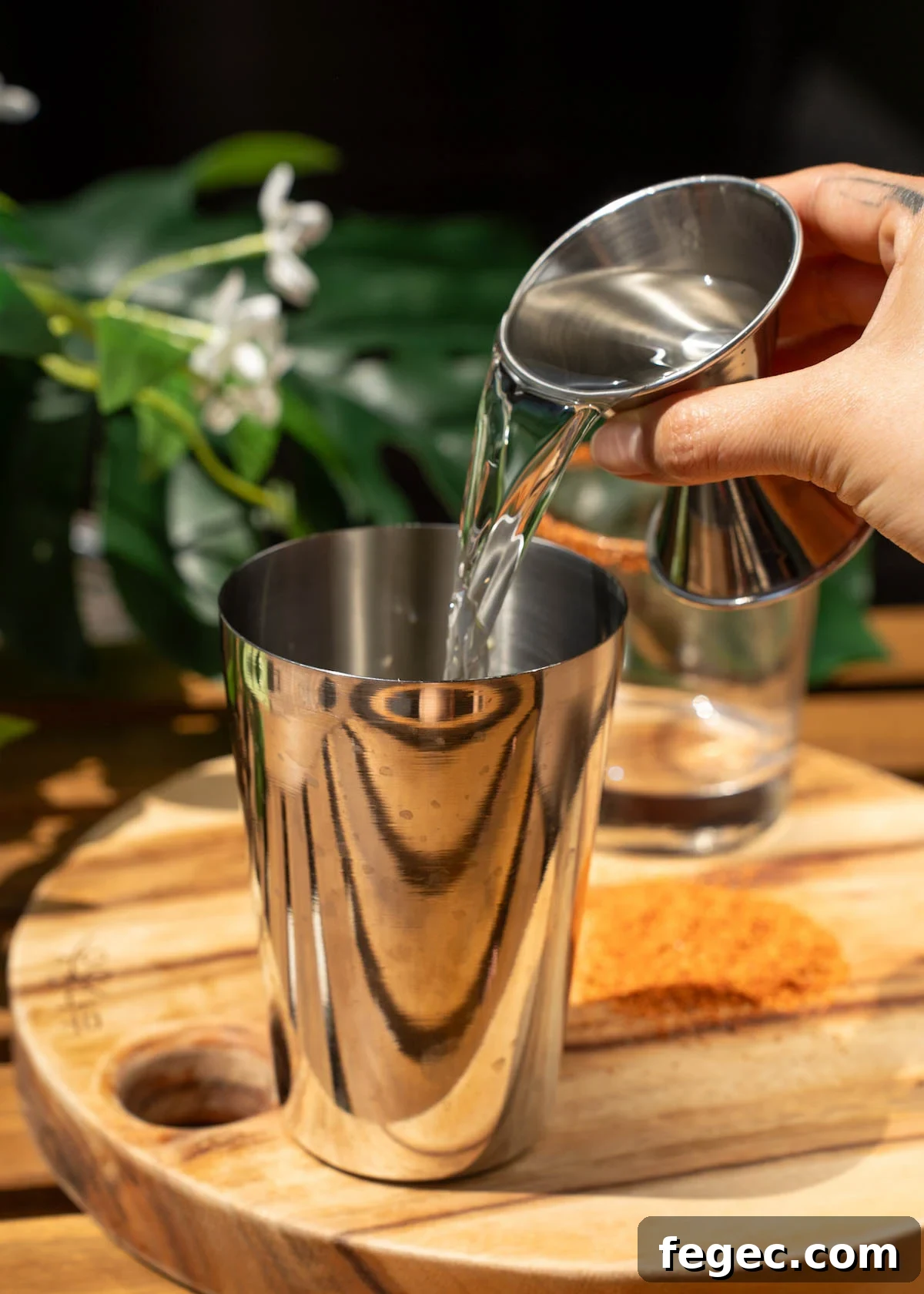 tequila being poured into a shaker