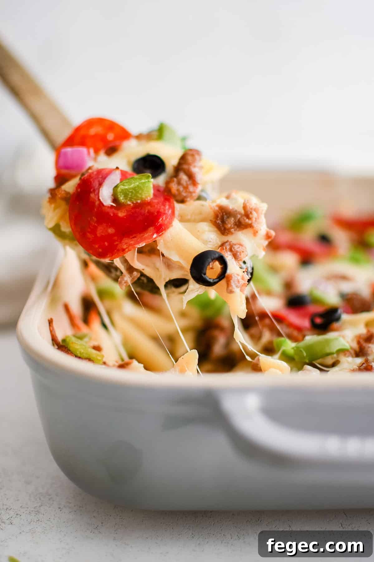 Creamy White Pizza Pasta Bake Recipe — Cheesy Italian Dinner 4 white pizza pasta on a serving spoon