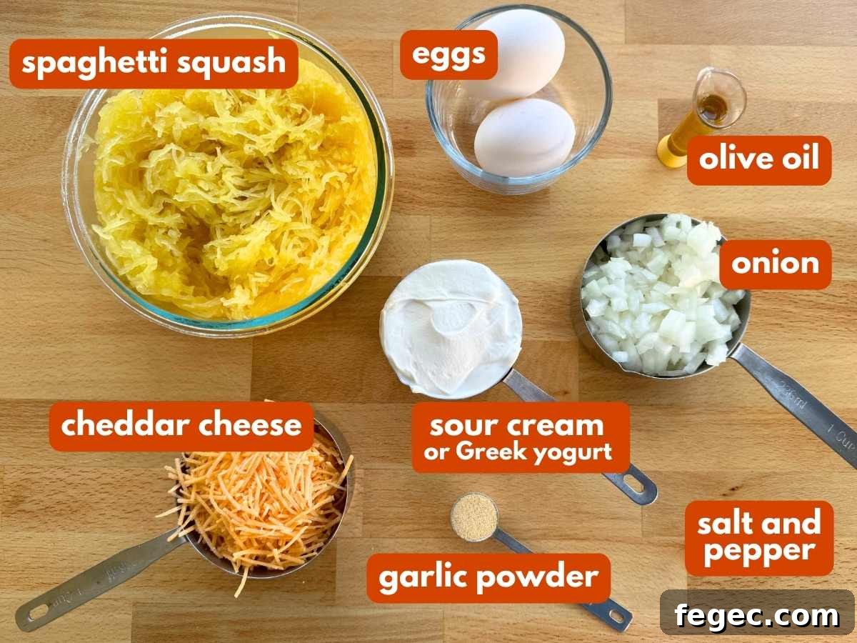 Spaghetti squash, eggs, cheddar cheese, sour cream, onion, olive oil, and garlic powder on a board.